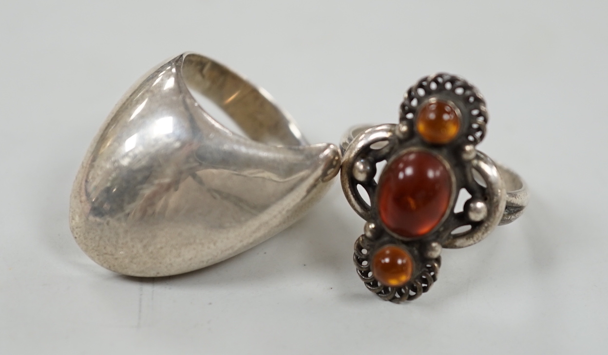 A Georg Jensen sterling ring, design no. 91, size Q and a Georg Jensen? sterling and three stone amber set ring, design no. 15.